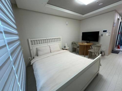 a bedroom with a bed and a table and a television at Tempus urban stay hotel in Daegu