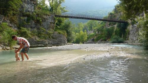 a man standing in the water near a river at Maison bord de rivière in Roquestéron