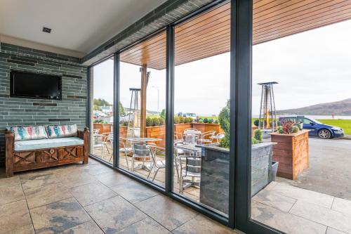 a living room with sliding glass doors and a patio at Lamlash Bay Hotel in Lamlash