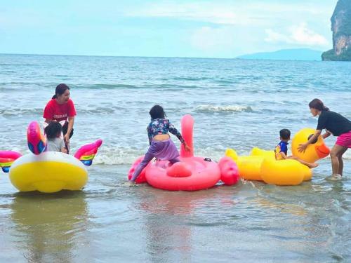 a group of children playing in the water at the beach at The Nanda Beach Resort in Sikao