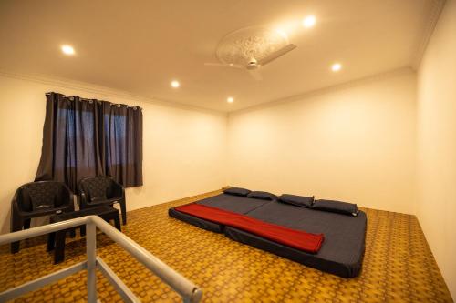a room with a bed and a chair in it at Sri Sai Holiday Inn in Puducherry