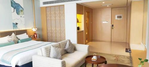 a bedroom with a bed and a couch and a table at Century Runhua Hotel in Jinan