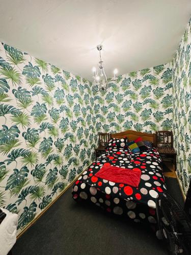 a bedroom with a bed with a tropical wallpaper at Backpackers Georgia in Tbilisi City
