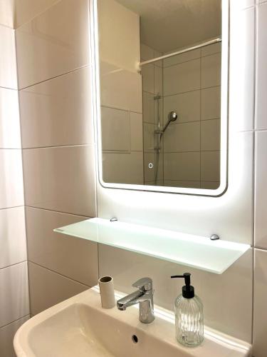 a bathroom with a sink and a mirror at Moderne Studio-Apartments in Wolfen in Steinfurth