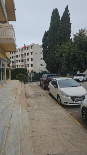 2 voitures garées dans un parking à côté d'un bâtiment dans l'établissement Beau studio avec parking, à Cagnes-sur-Mer