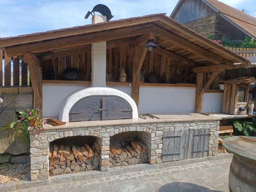 an outdoor brick oven with a wooden roof at Erlebnishof König-Kober in Pöllau