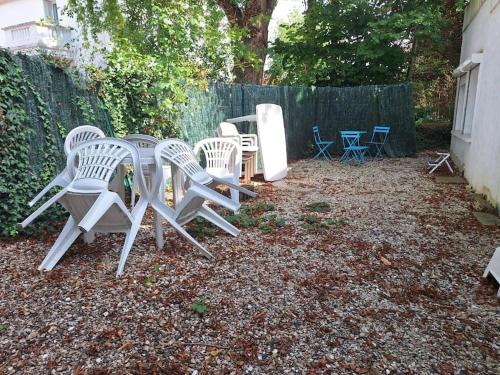a group of chairs and tables in a backyard at Studio meublé centre-ville 30 min Paris in Ris-Orangis