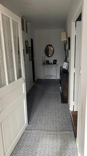 a hallway with a white door and a table at Maison de charme Bord de Loire -15mn des plages in Saint-Paimboeuf