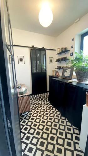 a room with a black door and a black and white floor at Maison de charme Bord de Loire -15mn des plages in Saint-Paimboeuf