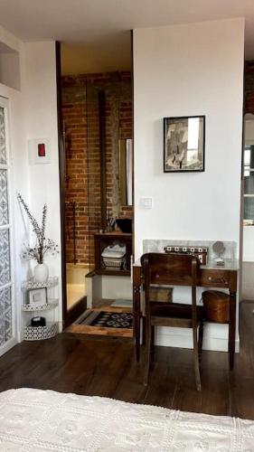 a room with a table and a chair and a desk at Maison de charme Bord de Loire -15mn des plages in Saint-Paimboeuf