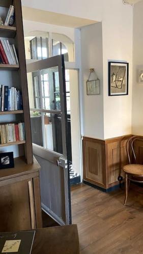 a living room with a book shelf and a door at Maison de charme Bord de Loire -15mn des plages in Saint-Paimboeuf