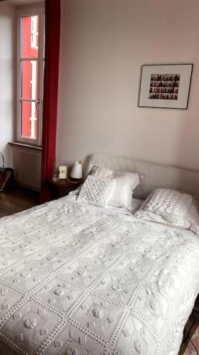 a bedroom with a white bed with pillows at Maison de charme Bord de Loire -15mn des plages in Saint-Paimboeuf