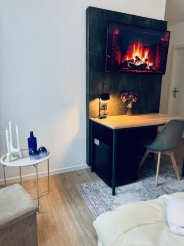 a living room with a desk and a fireplace at Hotel Charlton in Hannover
