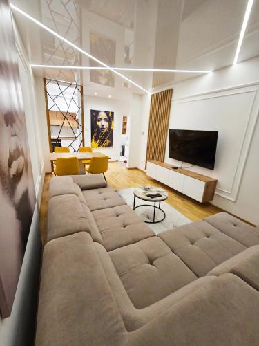 a living room with a large couch and a television at Square Garden 32 in Novi Sad