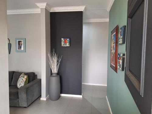 a living room with a couch and a vase at 1 CAMDEBO in Oudtshoorn
