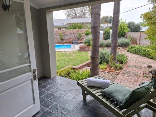 a porch with a chair and a view of a pool at 1 CAMDEBO in Oudtshoorn