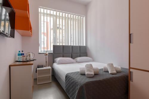a bedroom with a bed with two pillows on it at Esperanto Home in Katowice