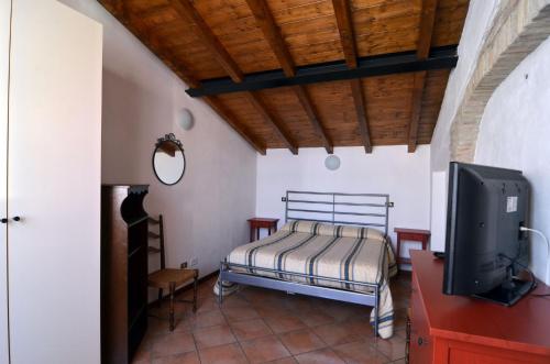a bedroom with a bed and a flat screen tv at Via Toscana House in Parma