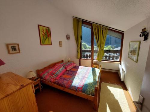 une chambre avec un lit et une grande fenêtre dans l'établissement Les Appartements Diochon, à Le Baplieu