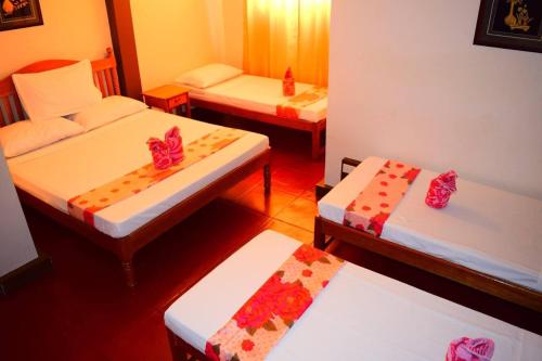 a room with three beds in a room at Princesa el gallo inn in Puerto Princesa City