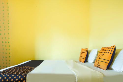 a bedroom with a bed with pillows on it at SPOT ON Saini Guest House in Roorkee