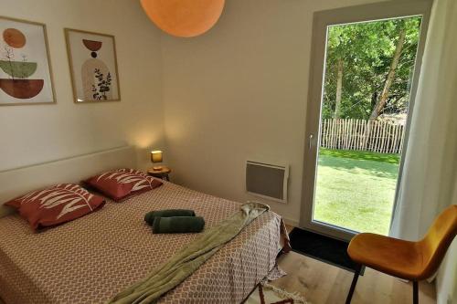 une chambre avec un lit et une grande fenêtre dans l'établissement La Villa Rivière & SPA, à Saint-Laurent-de-Médoc