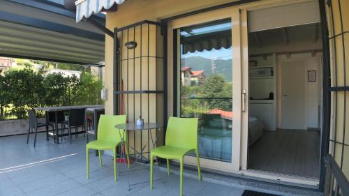 a patio with green chairs and a table on a balcony at A Nest 4 Family in Erba