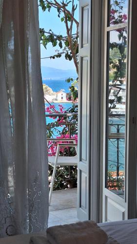 an open door to a balcony with a view of the ocean at Sea Colours Parga in Parga