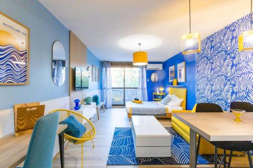 a living room with blue walls and a bedroom at Neon Oasis - Parking - Terrasse - Wifi - in Nîmes
