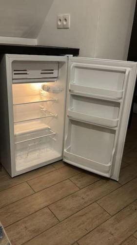 un réfrigérateur vide avec sa porte ouverte dans une cuisine dans l'établissement Bienvenue chez Angèle homes 3, à Niederbronn-les-Bains