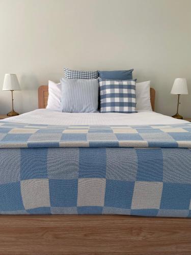 a blue and white bed with pillows on it at Euroa Motor Inn in Euroa