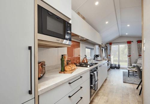 a kitchen with a stove and a tv on the wall at Ingoldale Holiday Park in Ingoldmells