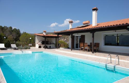 a villa with a swimming pool and a house at Lahtagas Estate with private swimming pool in Loutraki