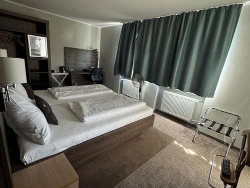a bedroom with two beds and a large window at L'Escala in Dreieich