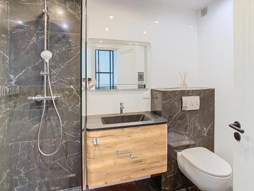 une salle de bain avec un lavabo, une douche et des toilettes dans l'établissement Appartements de Standing Cannes Centre, à Cannes