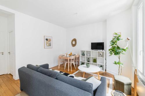 un salon avec deux canapés bleus et une table dans l'établissement Appartement 33m2 neuf cosy - Paris 12 - 4p - FLAT-GUEST, à Paris