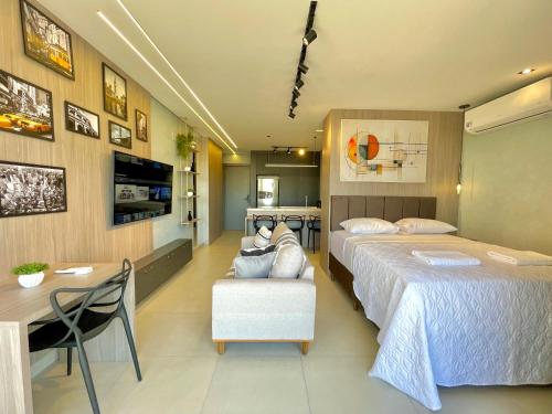 a hotel room with two beds and a desk at A Melhor Vista com Academia no Rooftop in Campo Grande