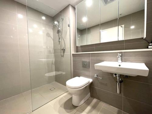a bathroom with a toilet and a sink and a shower at Stunning waterfront 3 bedroom condo with Pool, BBQ in Sydney