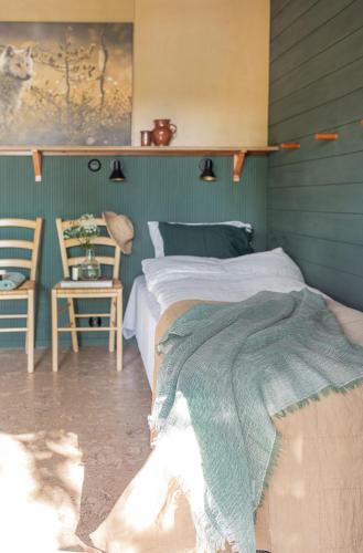 a bedroom with a bed with a green wall at Lakeside Villa next to Nuuksio National Park, in addition Hot Tub and Breakfast in Otalampi
