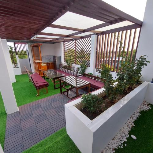a patio with a table and chairs on the grass at QV Manor Homestay in Phan Rang