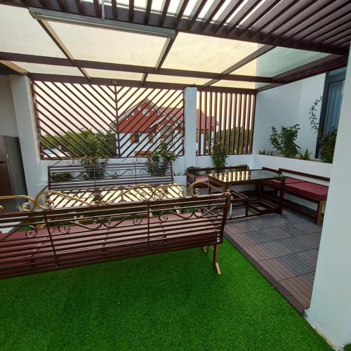 a patio with two benches and a table on a patio at QV Manor Homestay in Phan Rang