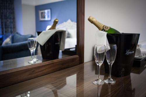 a bottle of champagne and two wine glasses on a counter at Inglewood House and Spa in Alloa