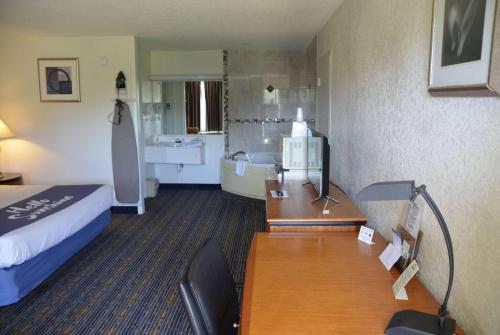 a hotel room with a bed a desk and a bathroom at Days Inn by Wyndham Luray Shenandoah in Luray