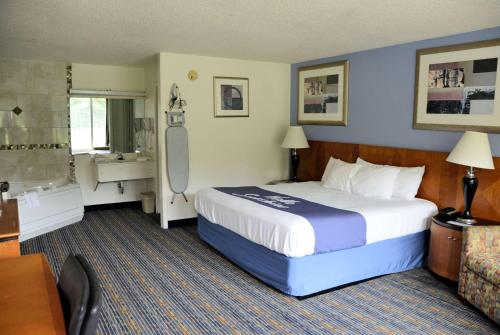 a hotel room with a bed and a bathroom at Days Inn by Wyndham Luray Shenandoah in Luray