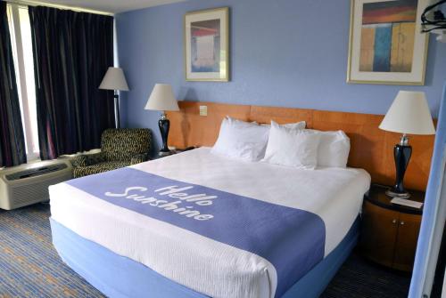 a hotel room with a large bed and a chair at Days Inn by Wyndham Luray Shenandoah in Luray