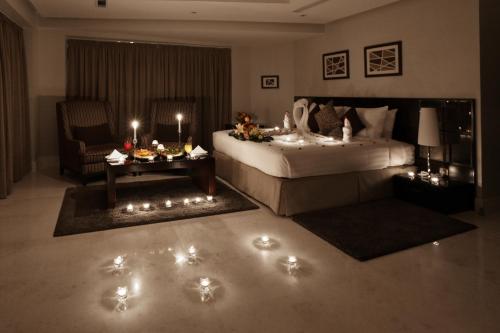 a bedroom with a bed and a table with lights at Aswar Al olaya for serviced Apartments in Al Khobar