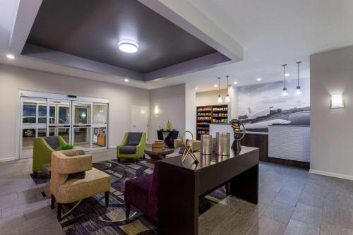 a living room with a couch and a table and chairs at La Quinta by Wyndham Huntsville Airport Madison in Madison