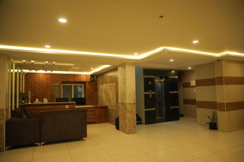 a living room with a couch and a kitchen at Hotel Roi Inn in Tirupati