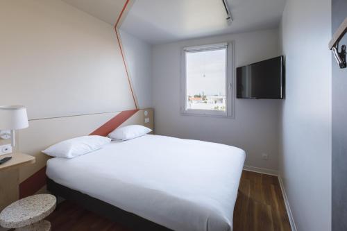 a bedroom with a white bed and a window at ibis budget Lyon Villeurbanne in Villeurbanne