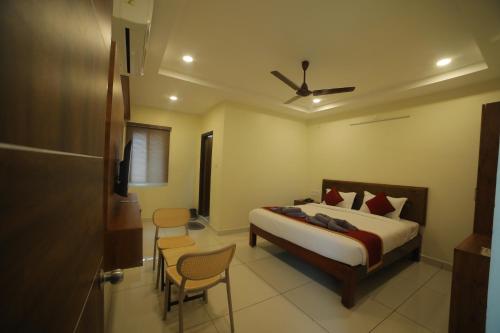 a bedroom with a bed and chairs in a room at Hotel Roi Inn in Tirupati